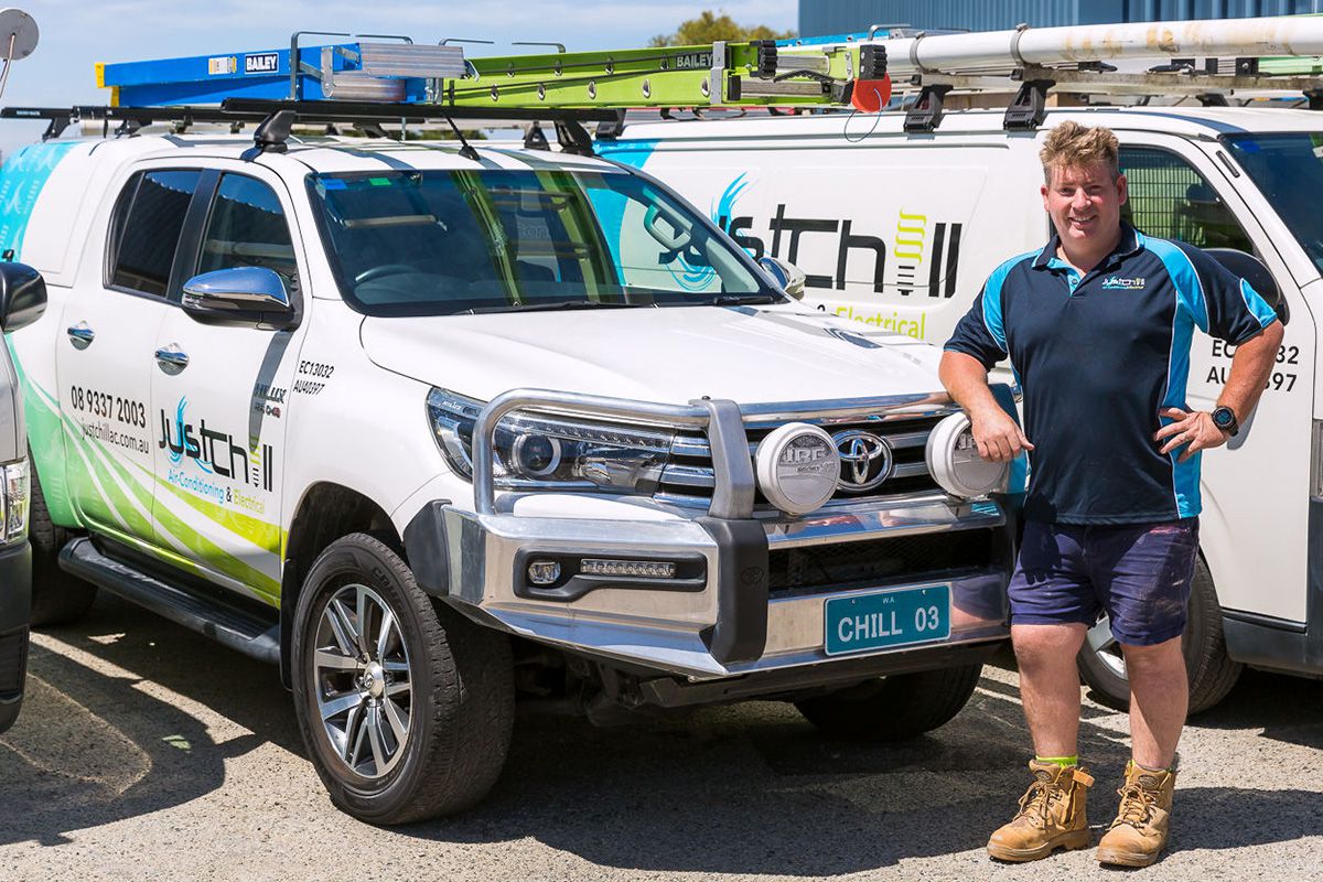 Brad from Just Chill standing beside a service van, ready for air con service.