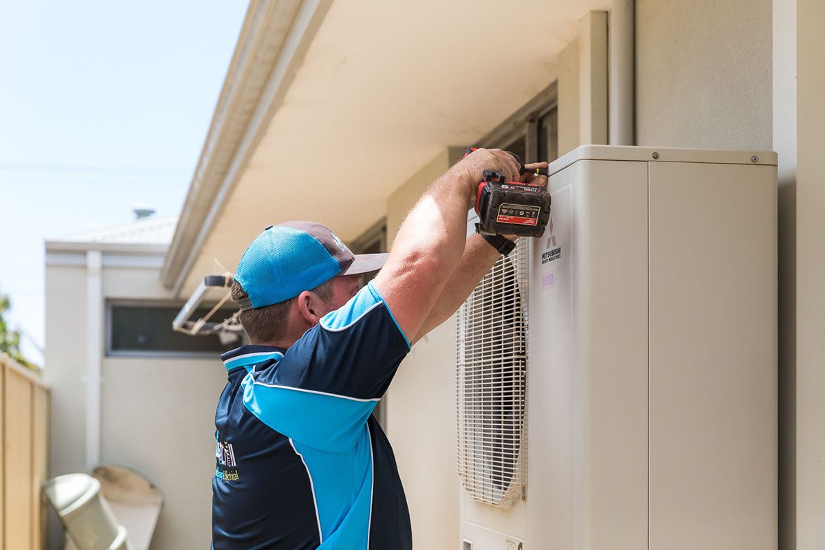 Brad performing maintenance on an outdoor air conditioning unit.