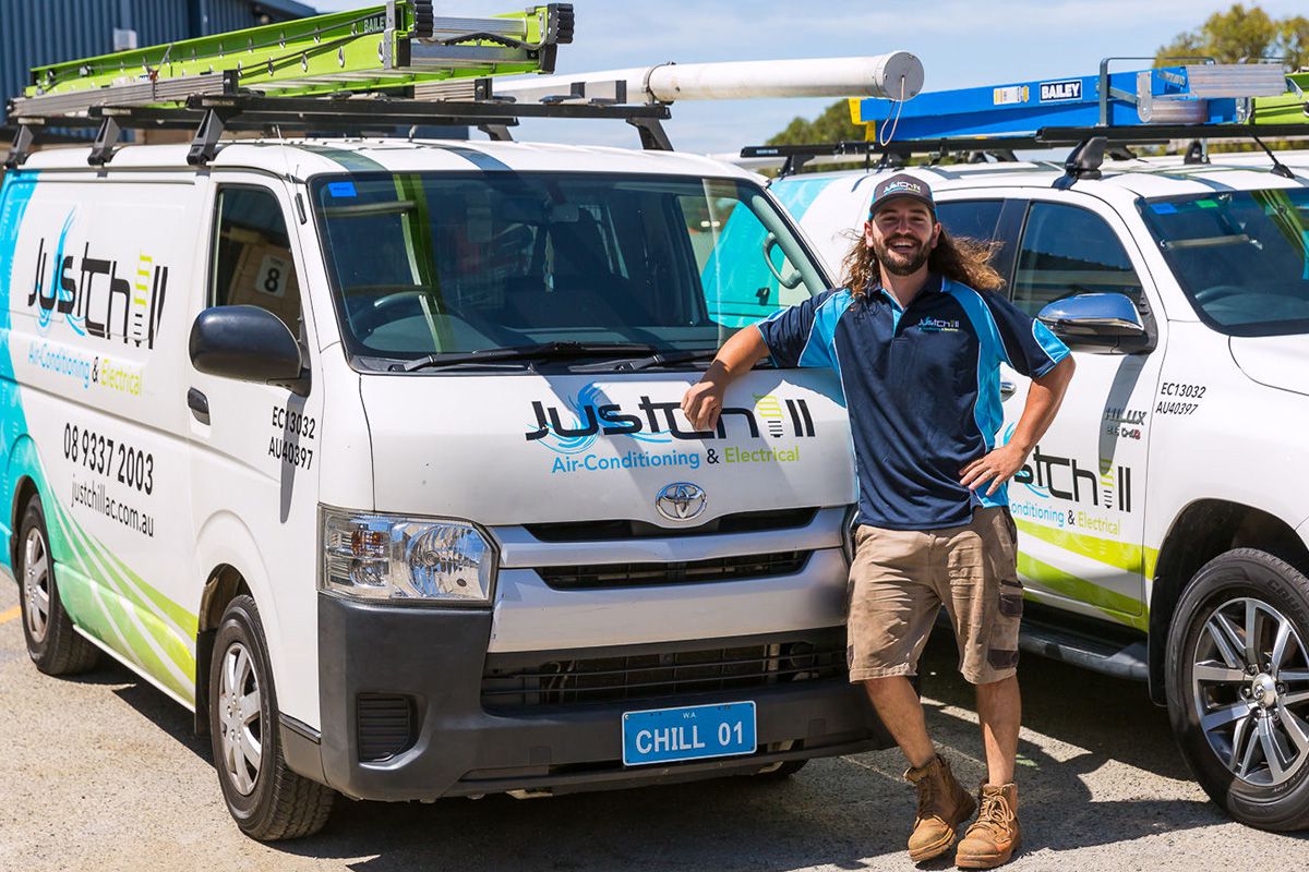 Technician Jamon from Just Chill posing beside a service van.